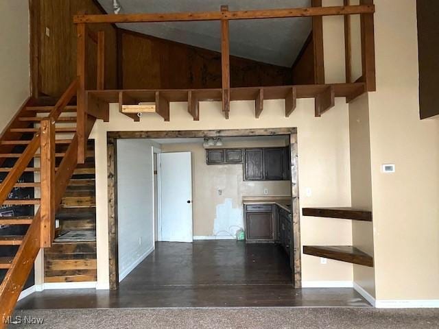 interior space with baseboards and high vaulted ceiling