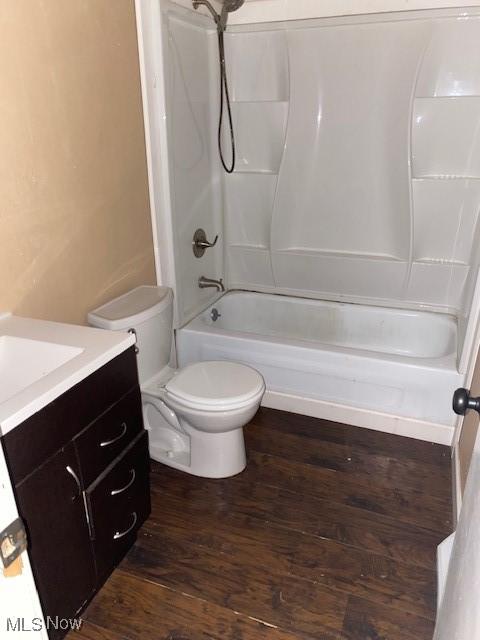 full bathroom featuring bathtub / shower combination, vanity, toilet, and wood finished floors