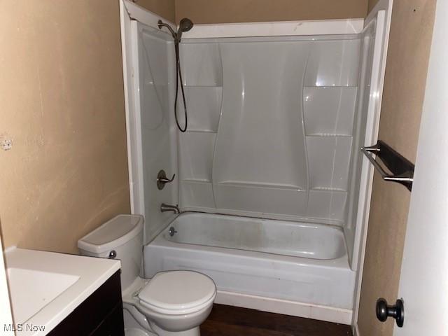 bathroom featuring washtub / shower combination, vanity, and toilet