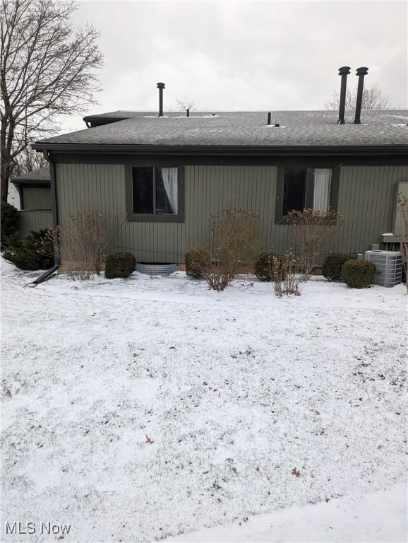 snow covered rear of property with central AC