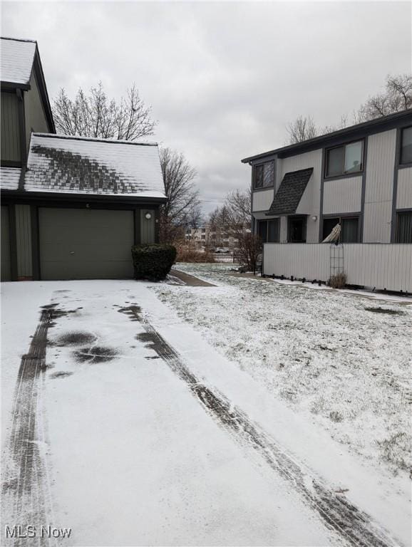 view of snow covered exterior with an attached garage