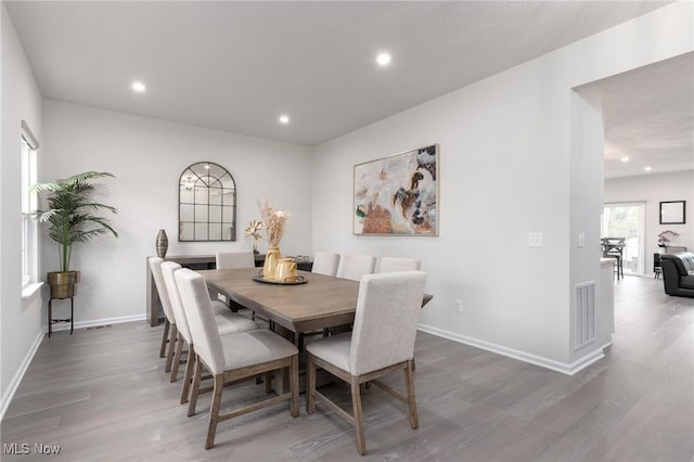 dining space featuring baseboards, wood finished floors, and recessed lighting