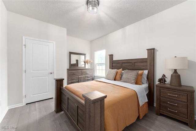 bedroom with a textured ceiling and wood finished floors