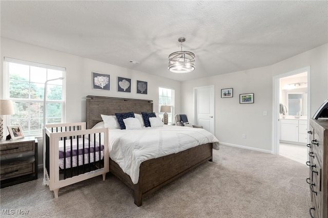 bedroom featuring light carpet, an inviting chandelier, baseboards, and a textured ceiling