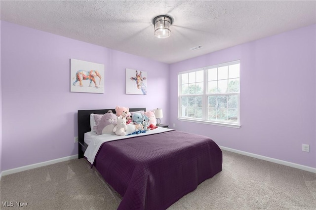 bedroom with carpet flooring, visible vents, baseboards, and a textured ceiling