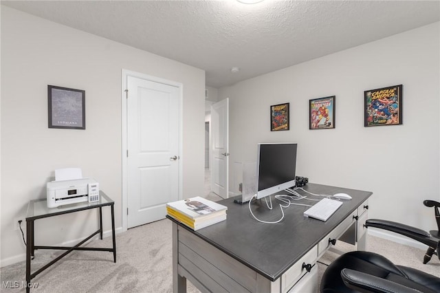 office space with light carpet, a textured ceiling, and baseboards