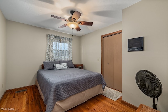 bedroom with visible vents, ceiling fan, baseboards, and wood finished floors