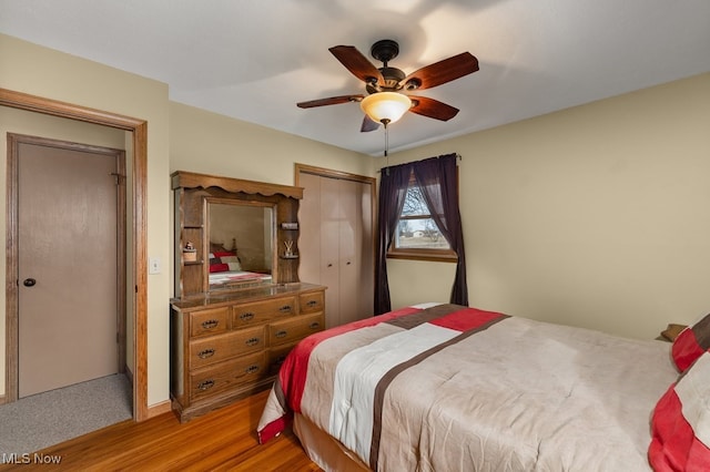 bedroom featuring light wood-style floors, ceiling fan, and a closet