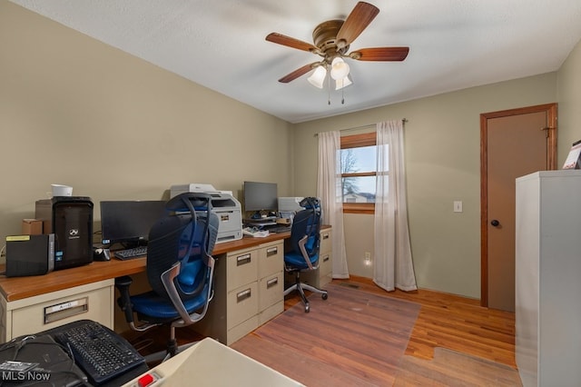 home office with light wood finished floors and a ceiling fan