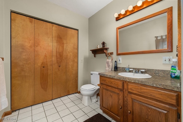 half bathroom featuring toilet, vanity, and tile patterned floors