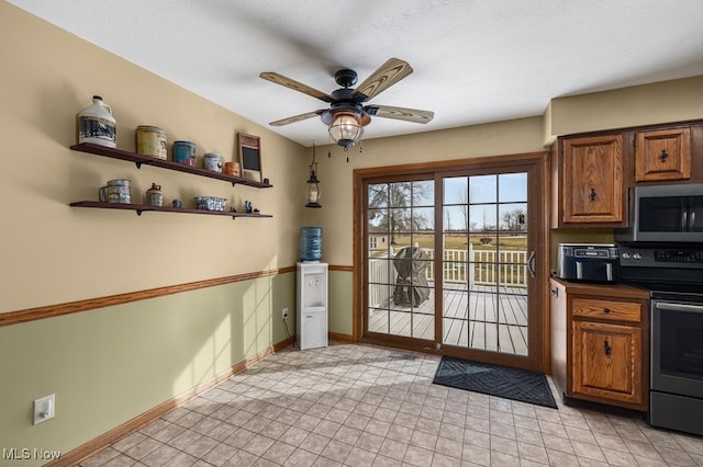 doorway to outside featuring a ceiling fan and baseboards