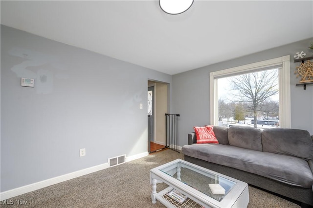 living room with carpet, baseboards, and visible vents