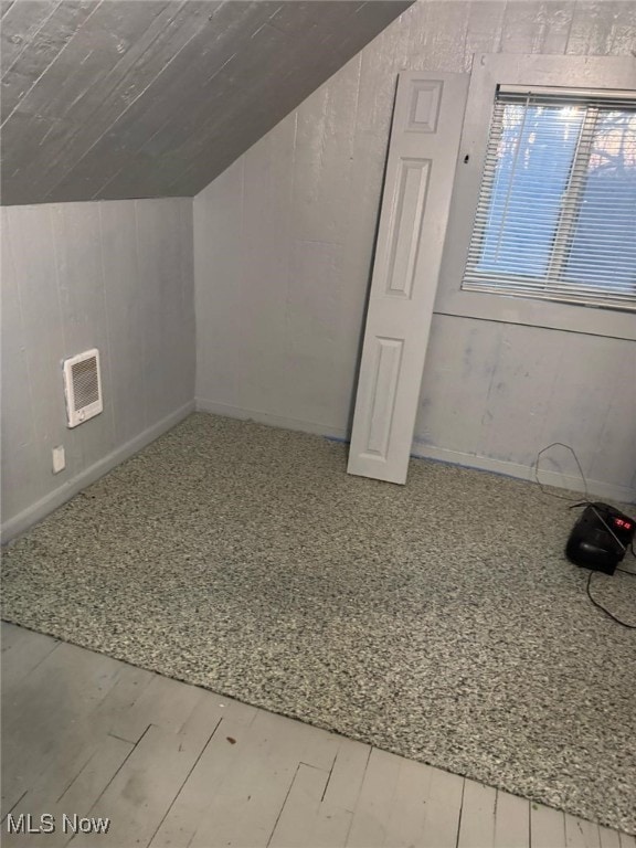 bonus room with lofted ceiling, visible vents, and wood finished floors