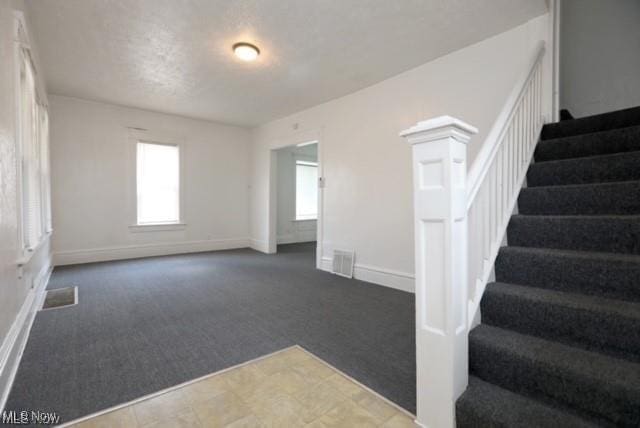 interior space featuring stairway, visible vents, and baseboards