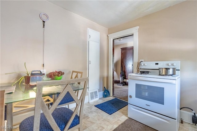 kitchen with light countertops, electric range, visible vents, and baseboards