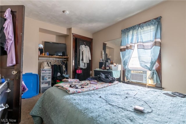 bedroom featuring carpet floors, cooling unit, a closet, and multiple windows