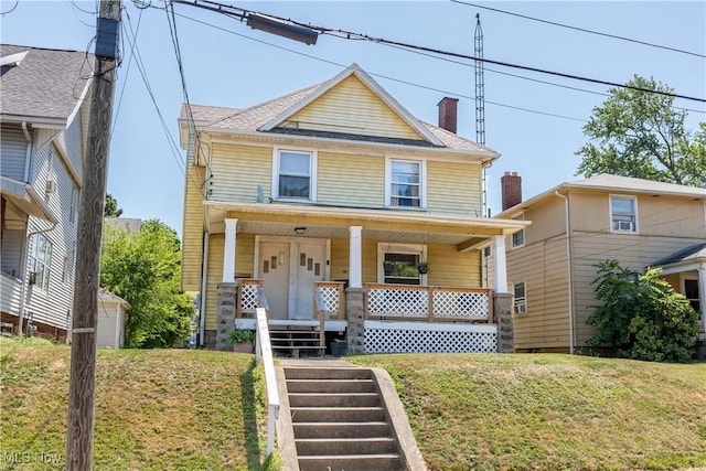 traditional style home with covered porch and a front lawn