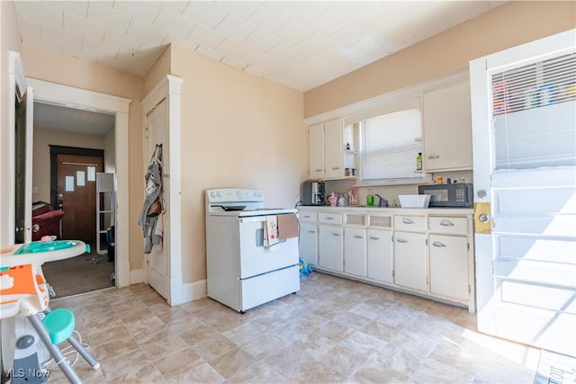 kitchen with black microwave, light countertops, electric range, and white cabinets