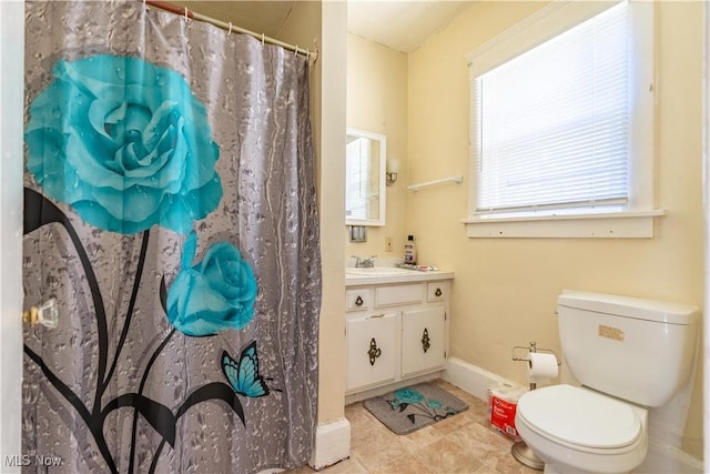 bathroom featuring toilet, baseboards, and vanity