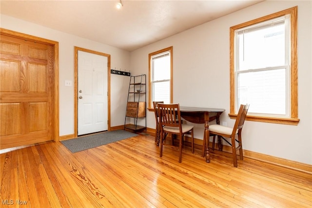 dining space featuring light wood-type flooring and baseboards