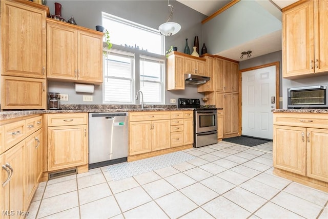 kitchen with stainless steel appliances, dark countertops, visible vents, a sink, and under cabinet range hood