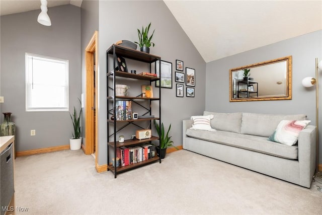 living area with vaulted ceiling, baseboards, and light colored carpet