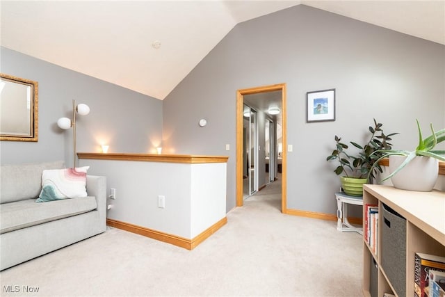 sitting room featuring lofted ceiling, light colored carpet, and baseboards