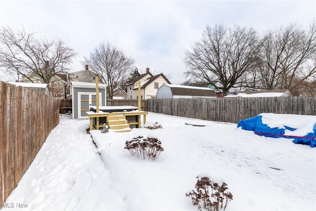 yard layered in snow featuring a fenced backyard