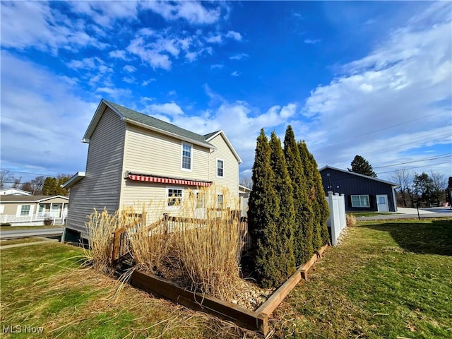 view of side of home with a garden and a lawn