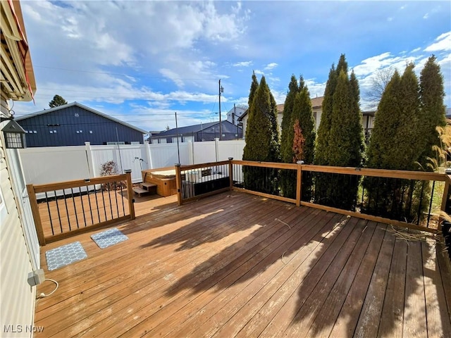 wooden deck featuring a hot tub and a fenced backyard