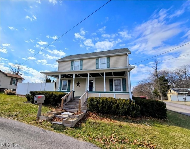 view of front facade featuring a porch, a front yard, and fence