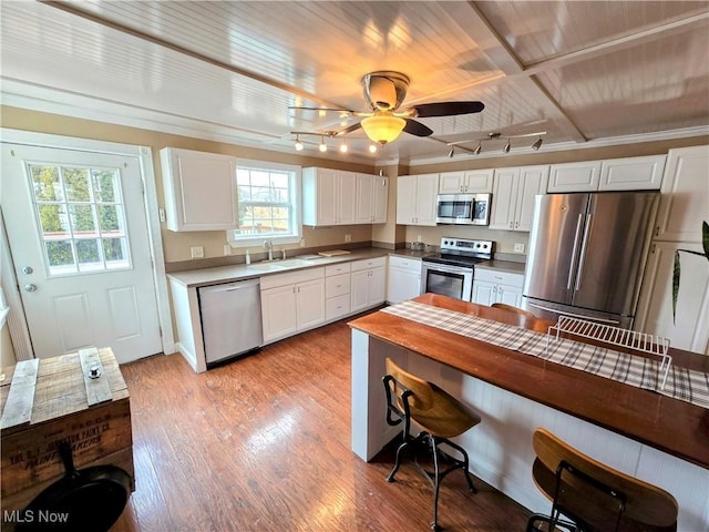 kitchen featuring stainless steel appliances, light wood-type flooring, white cabinets, and a sink