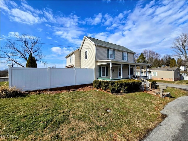 view of front of house featuring fence, a porch, and a front yard