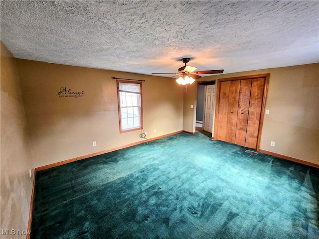 unfurnished bedroom featuring a textured ceiling, dark colored carpet, ceiling fan, and baseboards