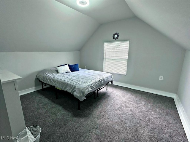 bedroom featuring vaulted ceiling, dark carpet, and baseboards