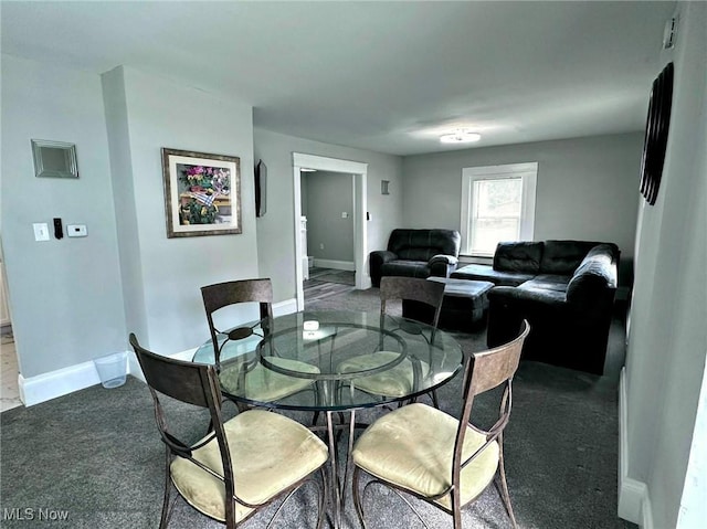 carpeted dining space featuring baseboards