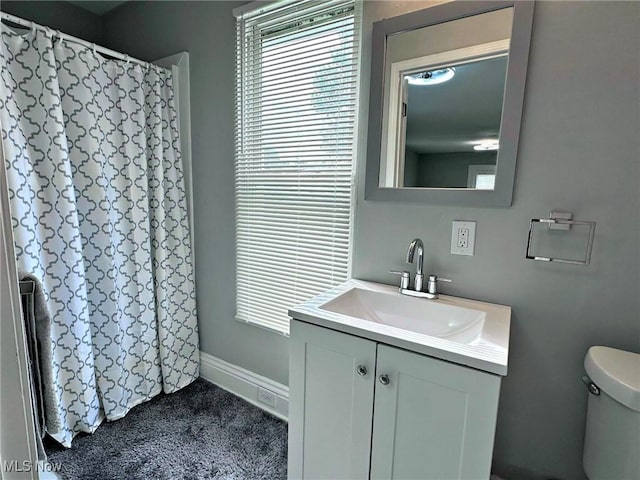 full bathroom featuring toilet, a shower with curtain, vanity, and baseboards