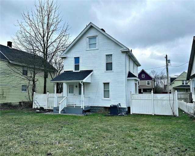 back of house featuring fence, cooling unit, and a yard