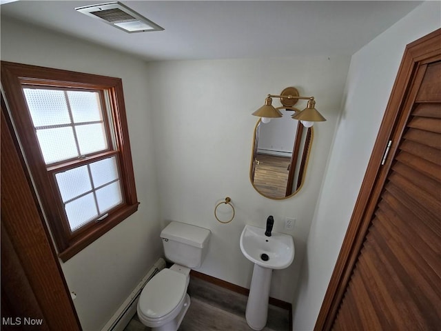 half bathroom with wood finished floors, baseboards, visible vents, toilet, and baseboard heating