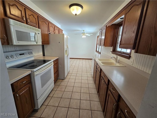 kitchen with ceiling fan, light countertops, light tile patterned flooring, white appliances, and a sink