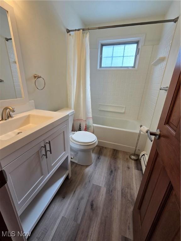 full bathroom featuring vanity, wood finished floors, shower / bath combo, a baseboard heating unit, and toilet