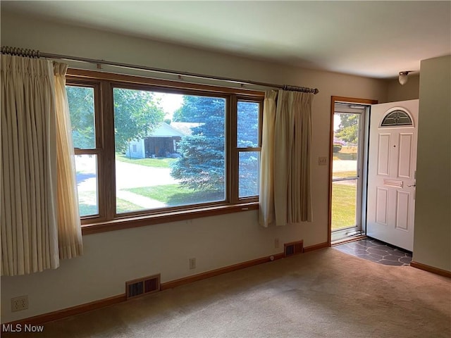 interior space featuring baseboards, visible vents, and dark carpet