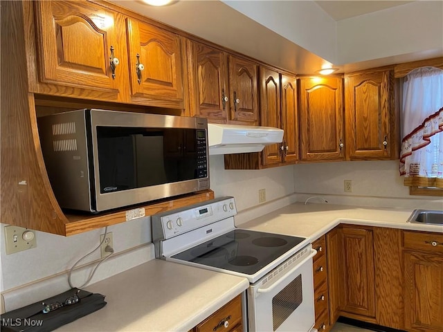 kitchen featuring white electric stove, light countertops, stainless steel microwave, and under cabinet range hood