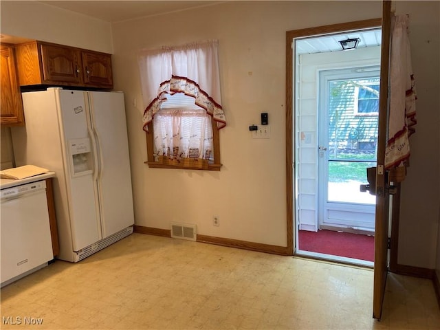 kitchen featuring white appliances, visible vents, a wealth of natural light, and light floors