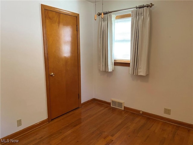 unfurnished bedroom with visible vents, light wood-style flooring, and baseboards