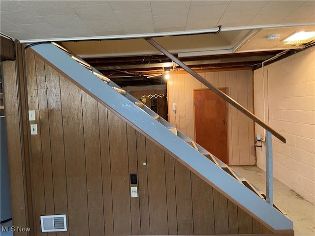 unfinished basement with concrete block wall and visible vents