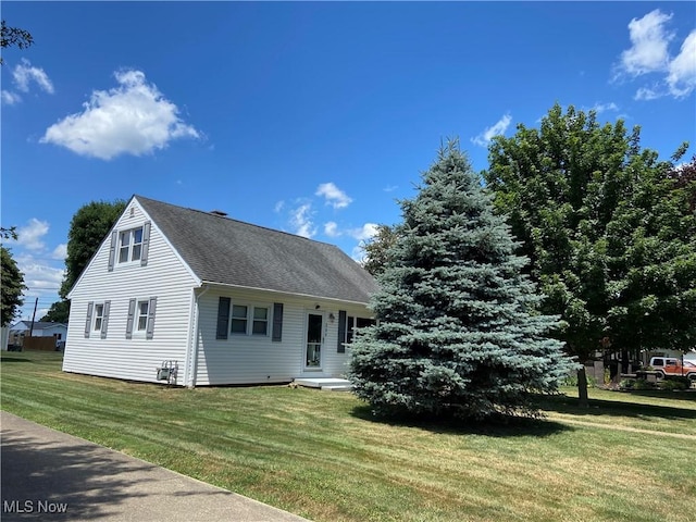 view of front of property featuring a shingled roof and a front yard