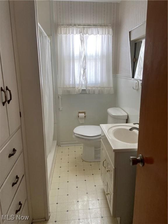 full bathroom with a shower with curtain, vanity, toilet, and tile patterned floors