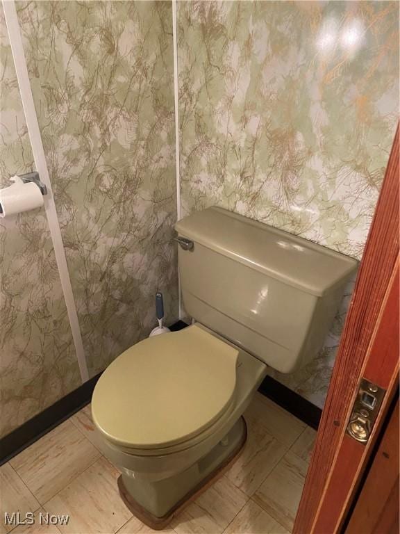 bathroom with toilet and wallpapered walls