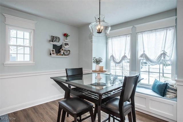 dining area featuring baseboards and dark wood-type flooring